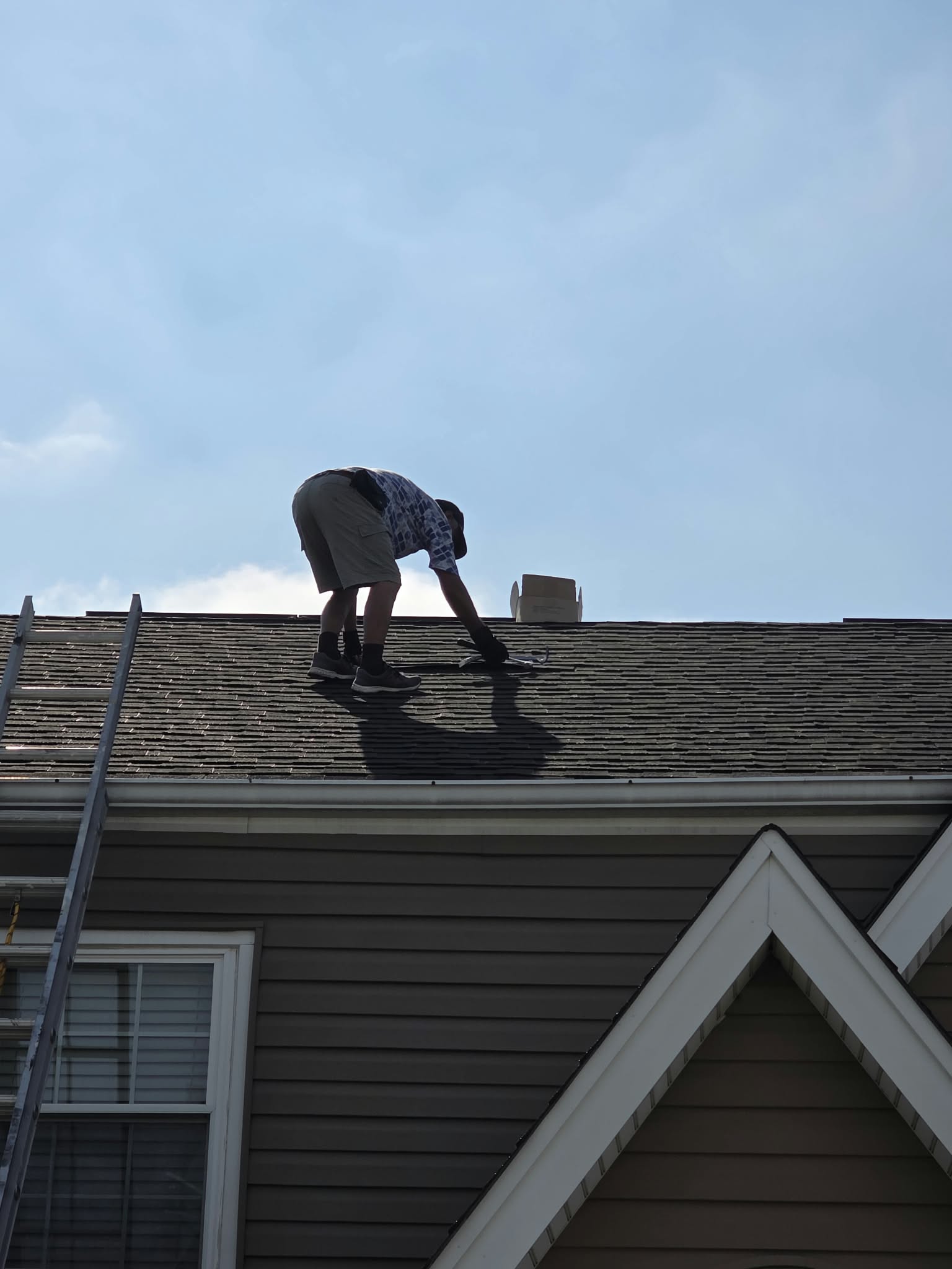 Technician repairing and guarding a rooftop solar array after animal damage